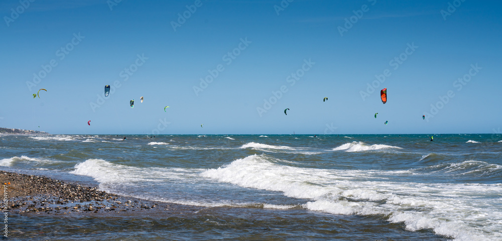 Kite Surfing Marbella. Many Kitesurfer agains a clear blue sky off a beach in Marbella on the Costa del Sol, Spain