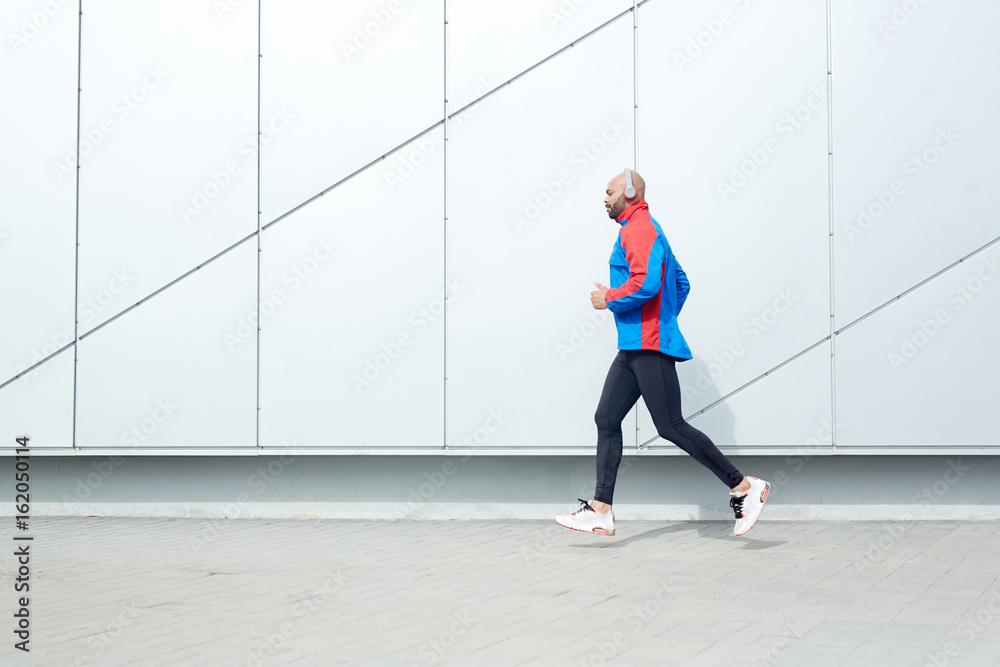 Young runner moving along wall Young runner moving along wall