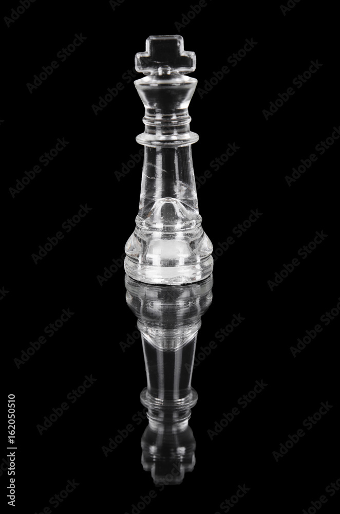 Glass chess king on black isolated background.