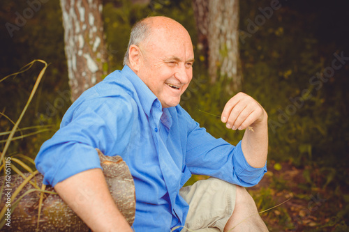 An elderly American man is joyful and cheerful enjoying life laughing and having fun outdoors in nature