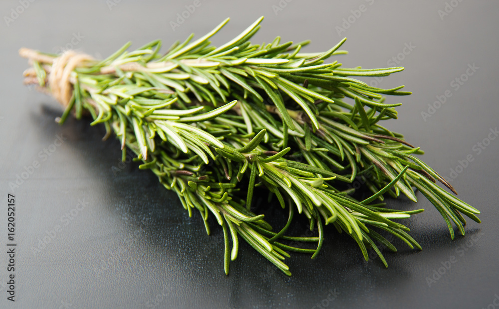 Sprigs of rosemary tied with string on a dark gray background. Sprigs of rosemary tied with string on a dark gray background.