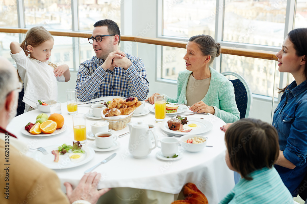 Big family having talk by breakfast in restaurant Big family having talk by breakfast in restaurant