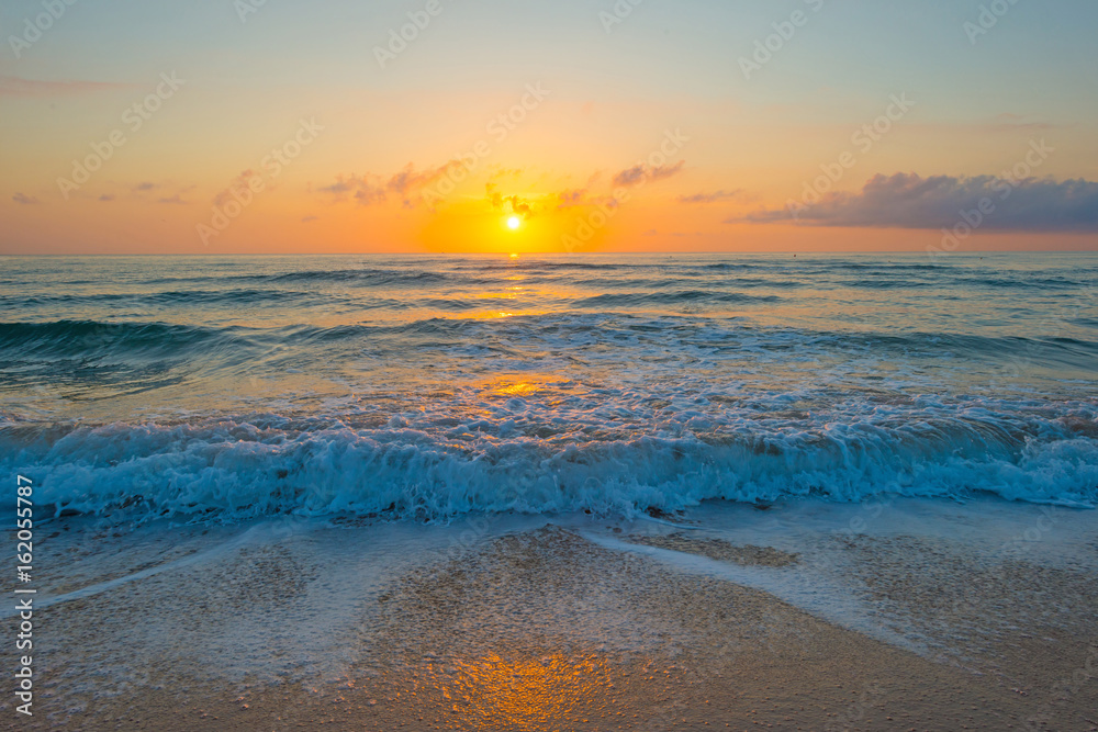 Sunrise over sea and sandy beach in spring