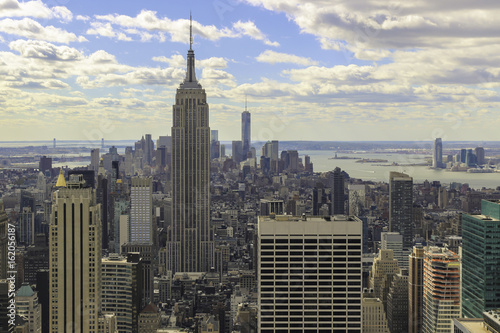 View of the Empire State Building and lower Manhattan as seen from the Rockefeller Center. Afternoon, cloudy skies