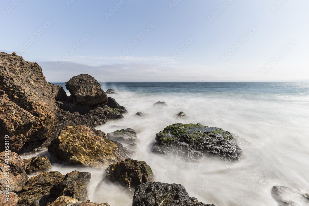 Pacific coast rocks and waves with motion blur at Point Dume in Malibu, California.