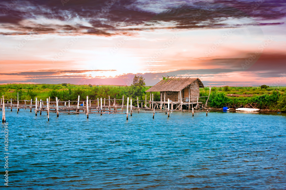 Naklejka premium Hut in a Beautiful Scene with Water, Land, Sky