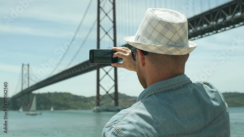 Man holding smartphone and captures the view on it, steadycam shot
 photo