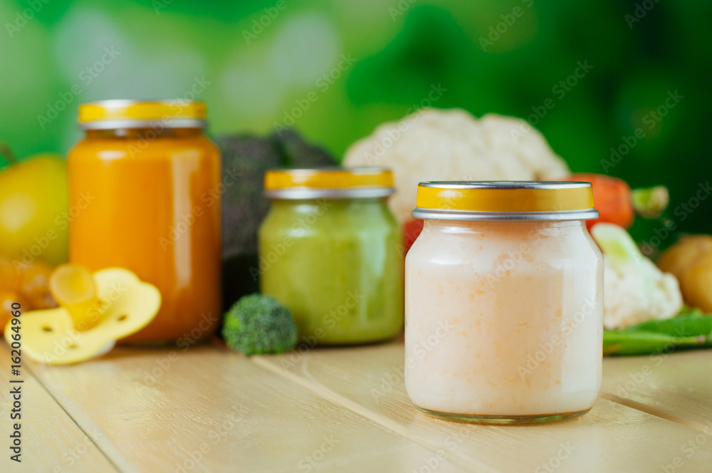 Jar with vegetable puree with spoon near fresh fruits and vegetables Jar with vegetable puree with spoon near fresh fruits and vegetables