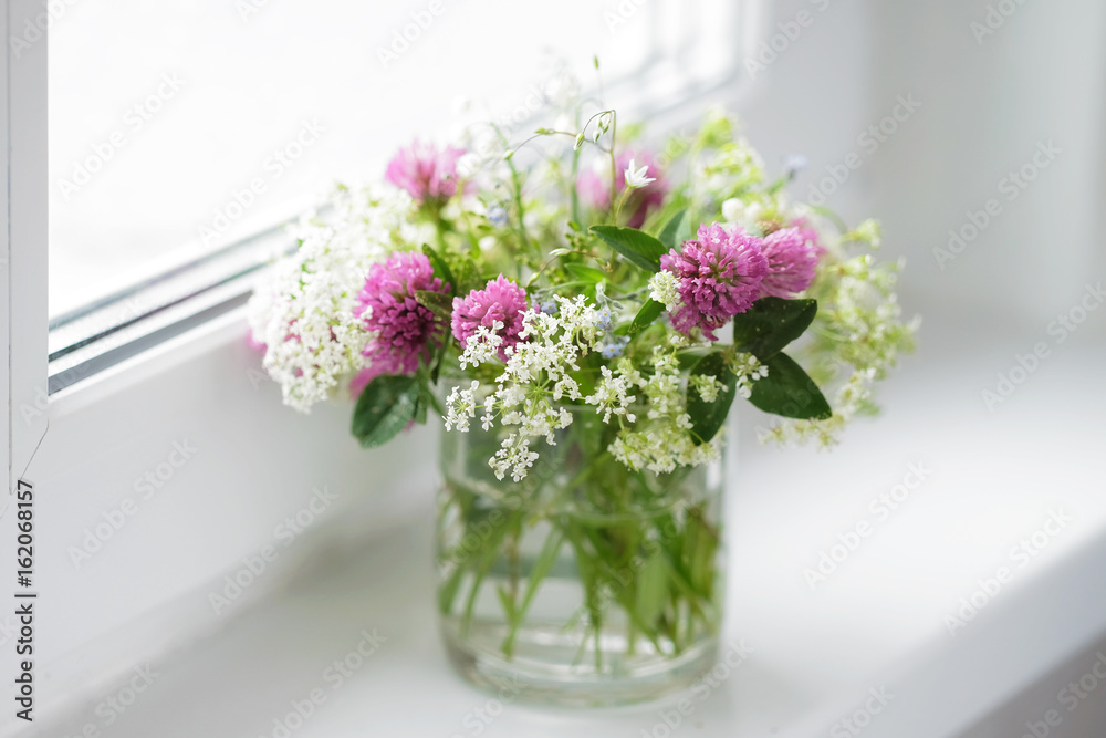A bouquet of wild flowers on the window, soft focus. A bouquet of wild flowers on the window, soft focus.