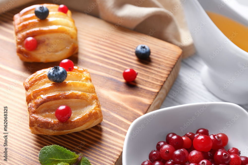 Wooden cutting board with pastries, closeup Wooden cutting board with pastries, closeup