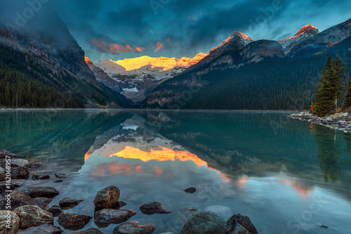 The First sunlight illuminating Victoria glacier on a calm morning in Autumn at Lake Louise in Banff National Park, Alberta, Canada. 