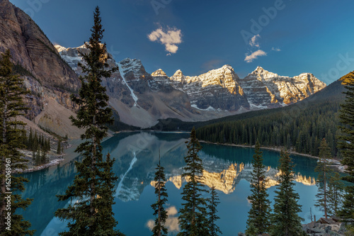 Majestic Moraine Lake in Banff National Park, Alberta. Stunning natural beauty, tall snow covered peaks, lush forest and wilderness and the jewel of the Canadian rocky mountains.