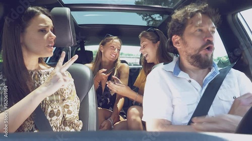 Teenage daughters laughing while parents are fighting in car unha photo