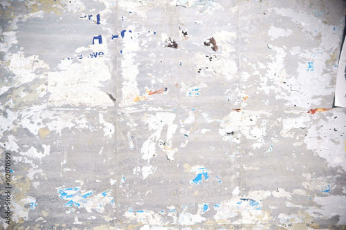 Papierfetzen an der Plakatwand  / Die Nahaufnahme einer Plakatwand mit abgerissenen Papierfetzen von Postern und Werbeplakaten.