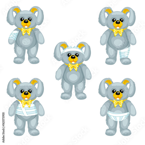 Gray plush bunny with bandages around the different parts of its body / There are five same plush bunnies with bandages on the hand, head, leg, thorax and perineum
