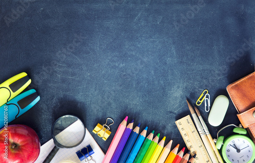 School supplies on black board background empty copy space. photo