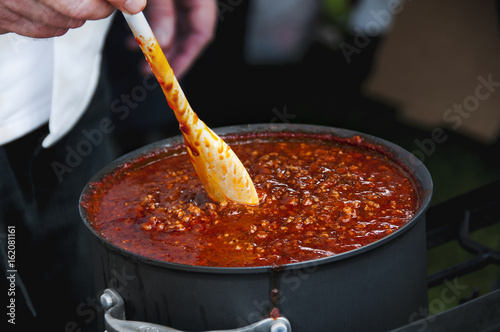 Cook Stirring a Simmering Pot of Spicy Chili Fototapeta