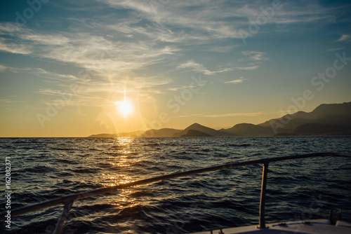 Coast of Montenegro at sunset, view from the sea, silhouettes of mountains photo