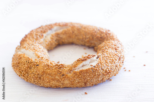 One bagel with sesam seeds on white background