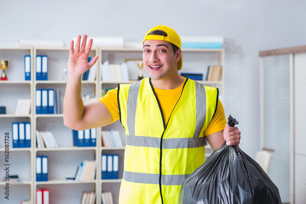 Man cleaning the office and holding garbage bag Man cleaning the office and holding garbage bag