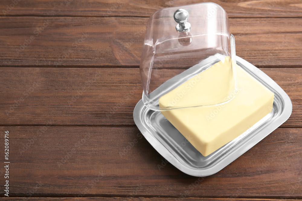 Dish with butter on wooden table Dish with butter on wooden table