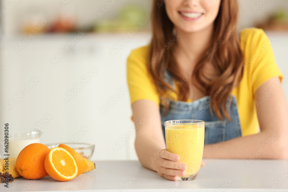 Weight loss concept. Beautiful young woman with healthy delicious smoothie in kitchen Weight loss concept. Beautiful young woman with healthy delicious smoothie in kitchen