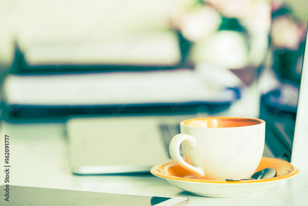 Cup of coffee and smart devices on the table close up. (Processed in vintage colour tone) Cup of coffee and smart devices on the table close up. (Processed in vintage colour tone)