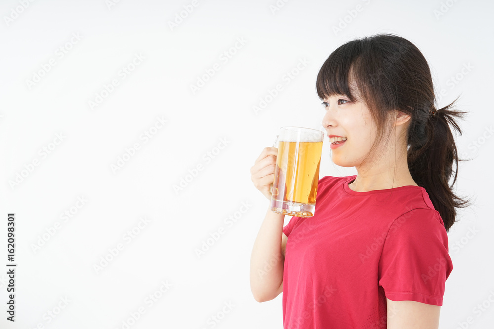Young woman cracking a beer after an exercise Young woman cracking a beer after an exercise