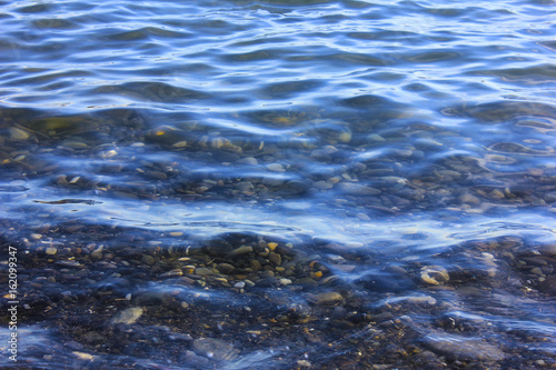 Transparent water surface with stony bottom.