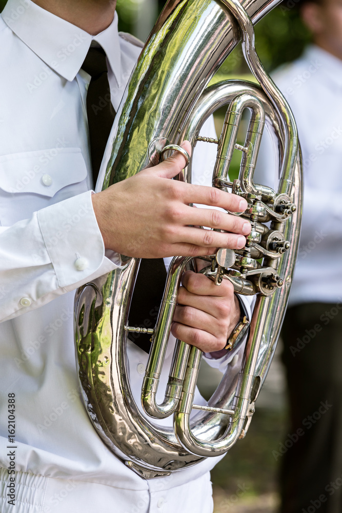Fototapeta premium military musician in white uniform playing on tuba. brass bands fest.