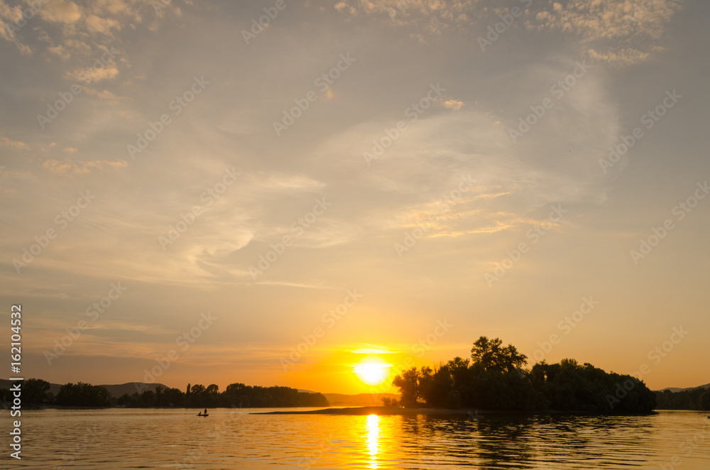 Fototapeta premium sunset on beach in summer, cloudy sky sunset with sun optics, summertime on beach