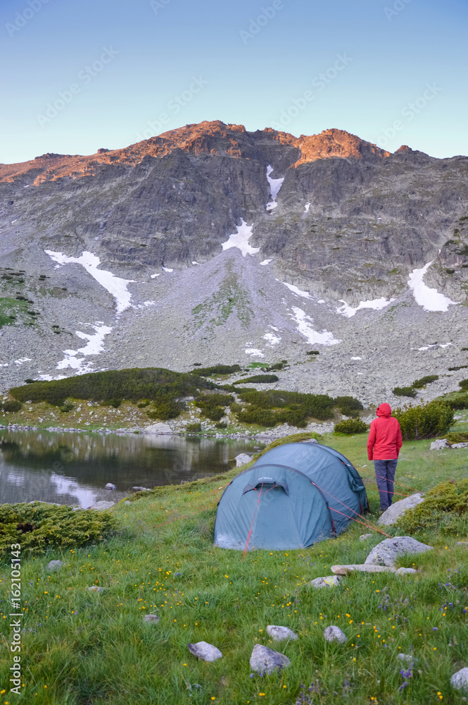 Woman and a tent in mountains