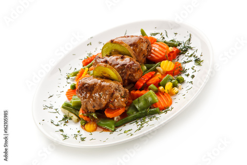 Wrapped pork chops and vegetables on white background 