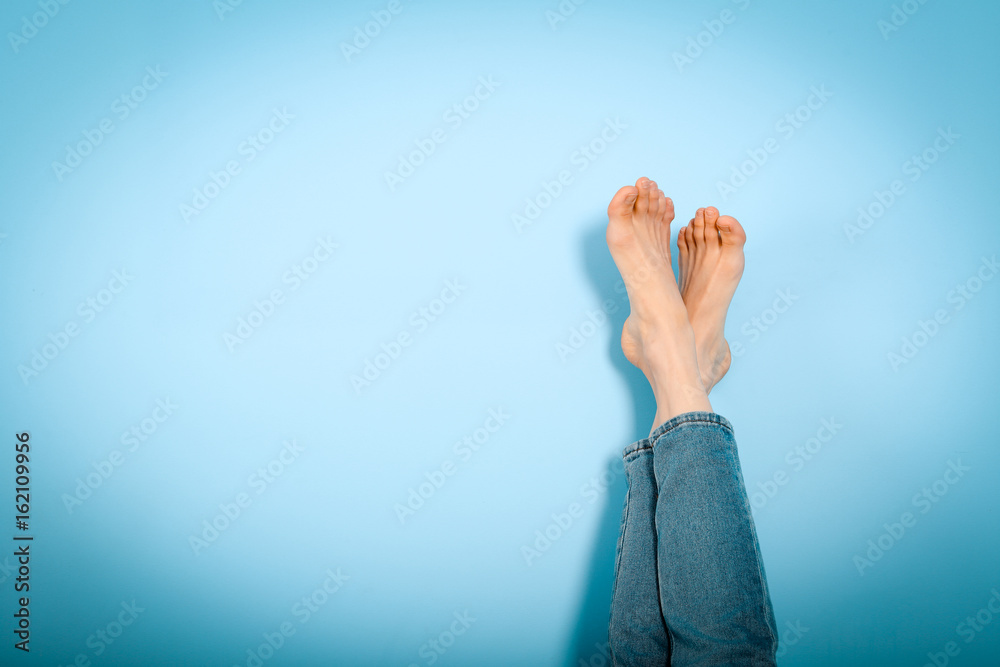 © Елена Кравчук - Female legs foot on foot on blue background, resting, holiday