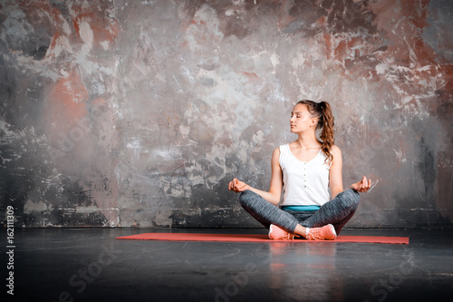 Yoga woman in lotus, healthy lifestyle, sitting on pink mat, urb