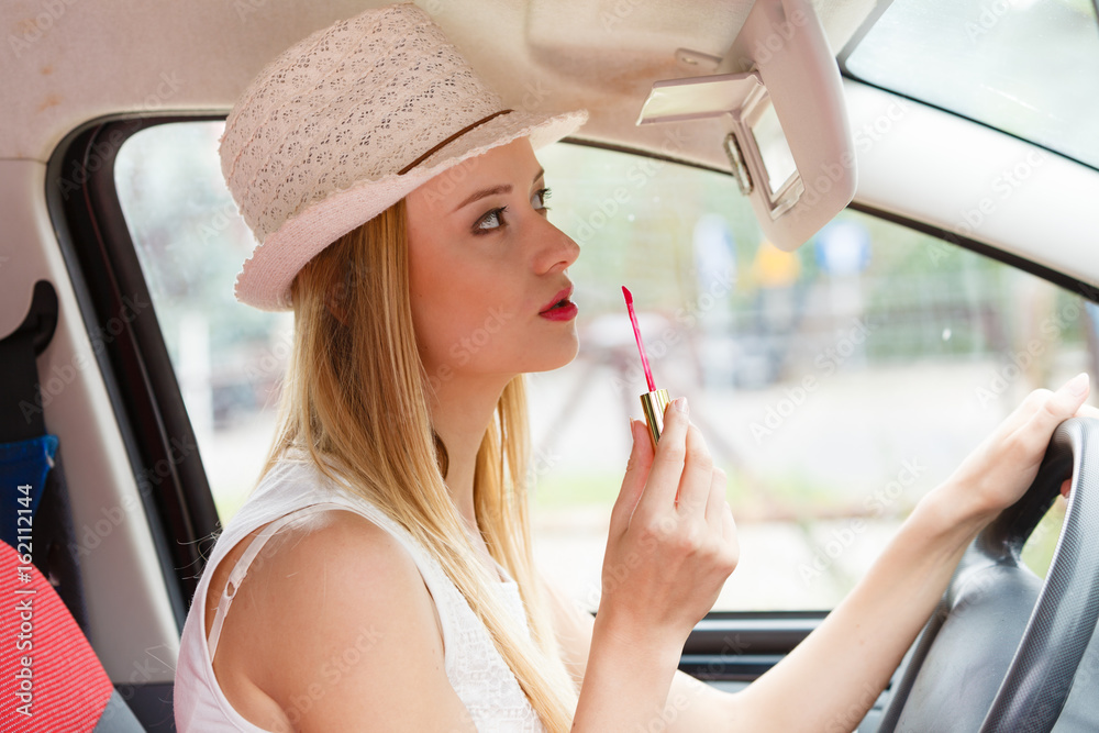 Woman applying makeup while driving her car Woman applying makeup while driving her car