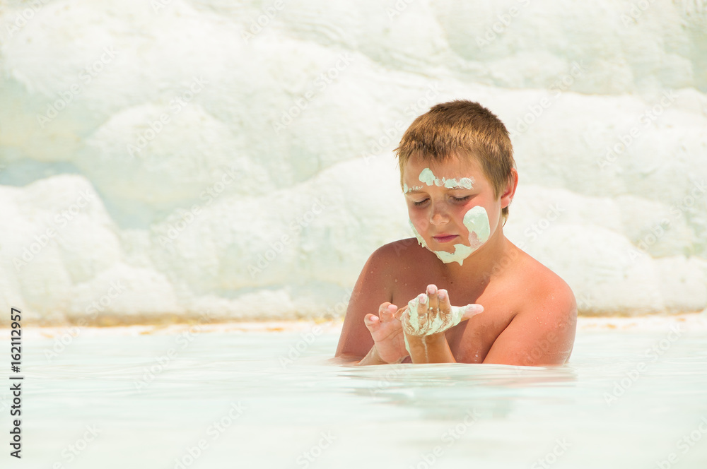 Fototapeta premium The child swims in the Pamukkah tram. Wellness baths.