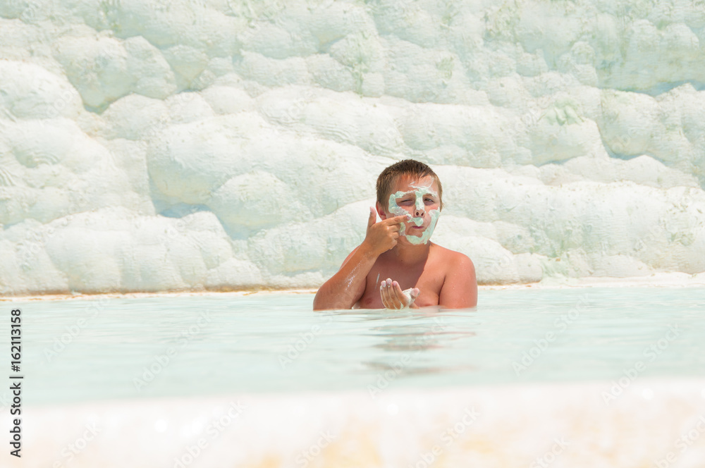 Fototapeta premium The child swims in the Pamukkah tram. Wellness baths.