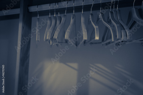 Choice of fashion clothes of different colors on wire hangers