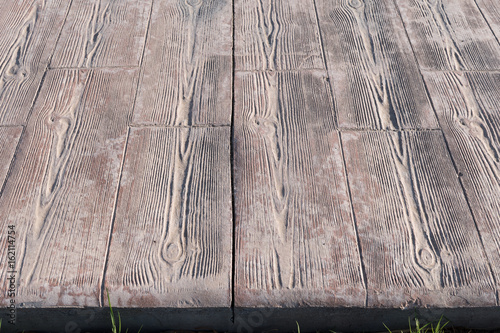stamped concrete pavement close up detail expansion joint at middle, Wooden slats pattern, flooring exterior, decorative texture of cement paving with streaks of wood