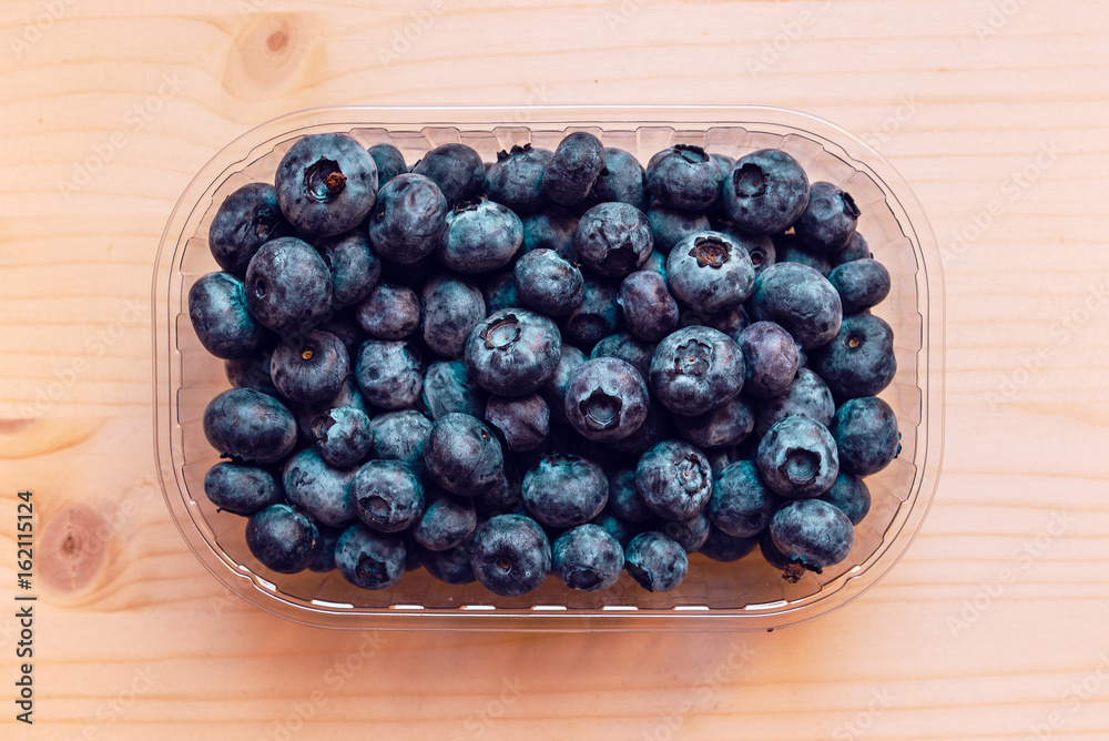 Fresh blueberries in plastic container box, top view Fresh blueberries in plastic container box, top view