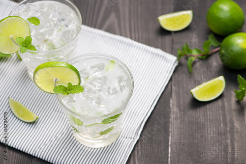 Fresh cocktail with lime, ice and mint on a rustic background. Copy space, top view