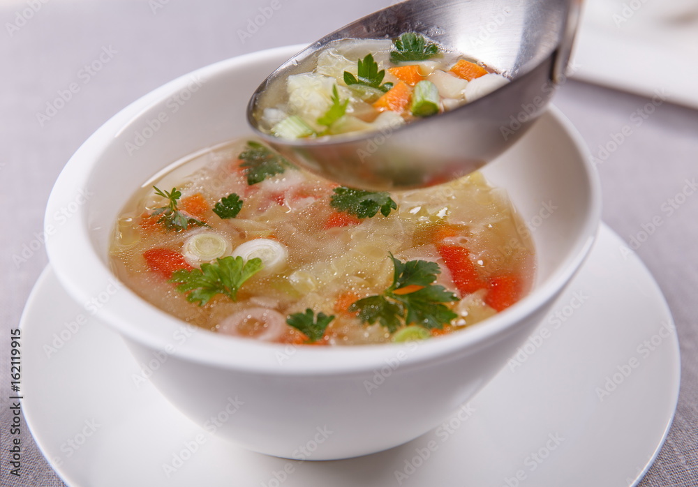 Fresh vegetable soup made of cabbage, carrot, potato, red bell p Fresh vegetable soup made of cabbage, carrot, potato, red bell p