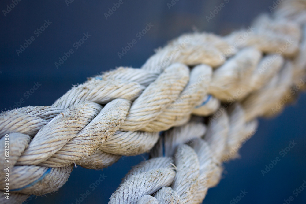 Ropes on the background of the sea. Old sea ropes for mooring ships, yachts and boats. Port Wharf