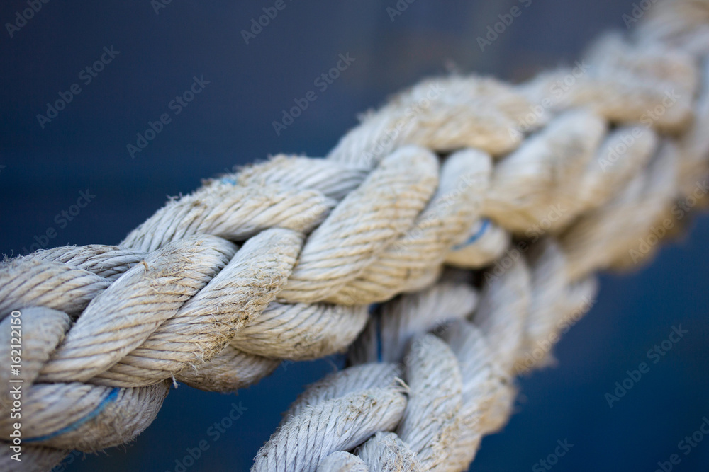 Ropes on the background of the sea. Old sea ropes for mooring ships, yachts and boats. Port Wharf Ropes on the background of the sea. Old sea ropes for mooring ships, yachts and boats. Port Wharf