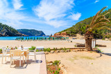 Restaurant table on sunny terrace on Cala Benirras beach, Ibiza island, Spain