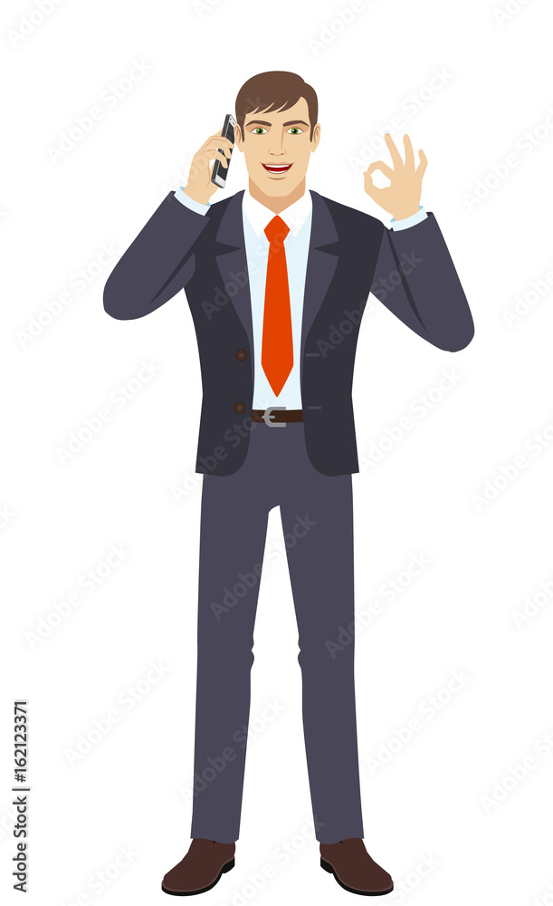 Businessman talking on the mobile phone and showing a okay hand sign Businessman talking on the mobile phone and showing a okay hand sign