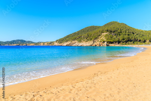 Sandy beach and calm beautiful sea water in Cala San Vicente bay on sunny summer day  Ibiza island  Spain