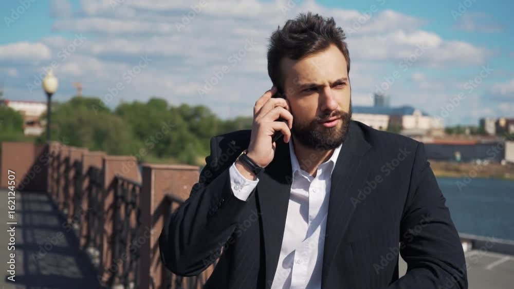 Businessman talking on the phone and very angry. He yells and swears. In slow motion Businessman talking on the phone and very angry. He yells and swears. In slow motion