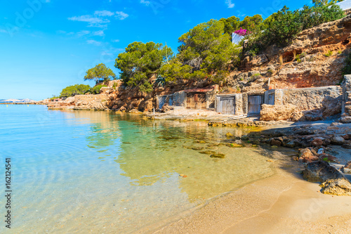 View of beautiful Cala Gracio beach with boat houses on shore at early morning, Ibiza island, Spain